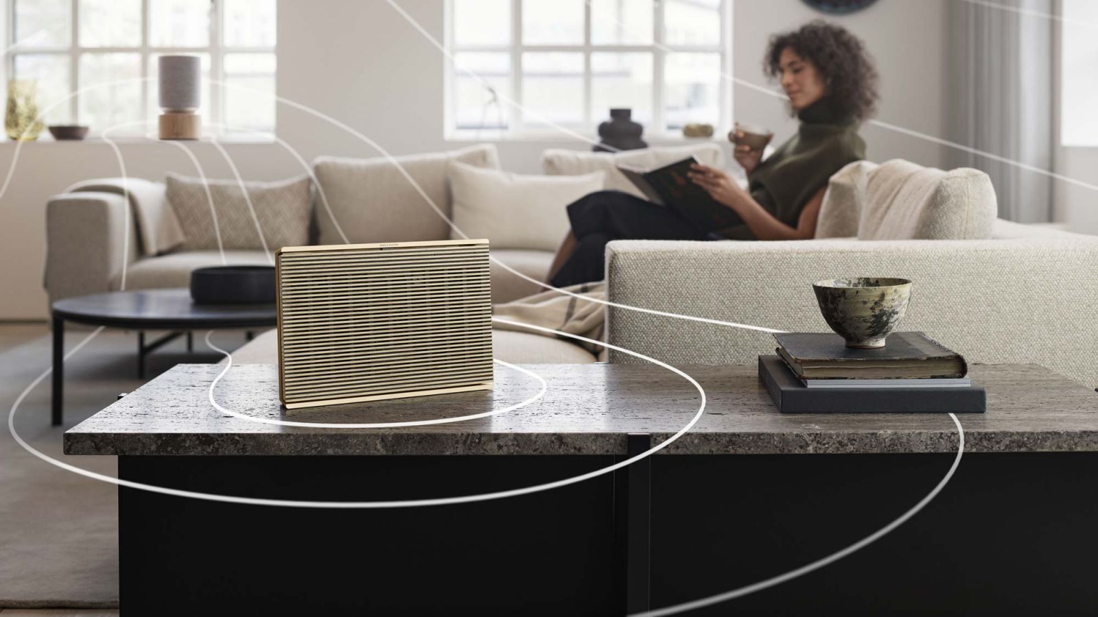 Woman relaxing with a wireless multi-room speaker streaming music in a living room