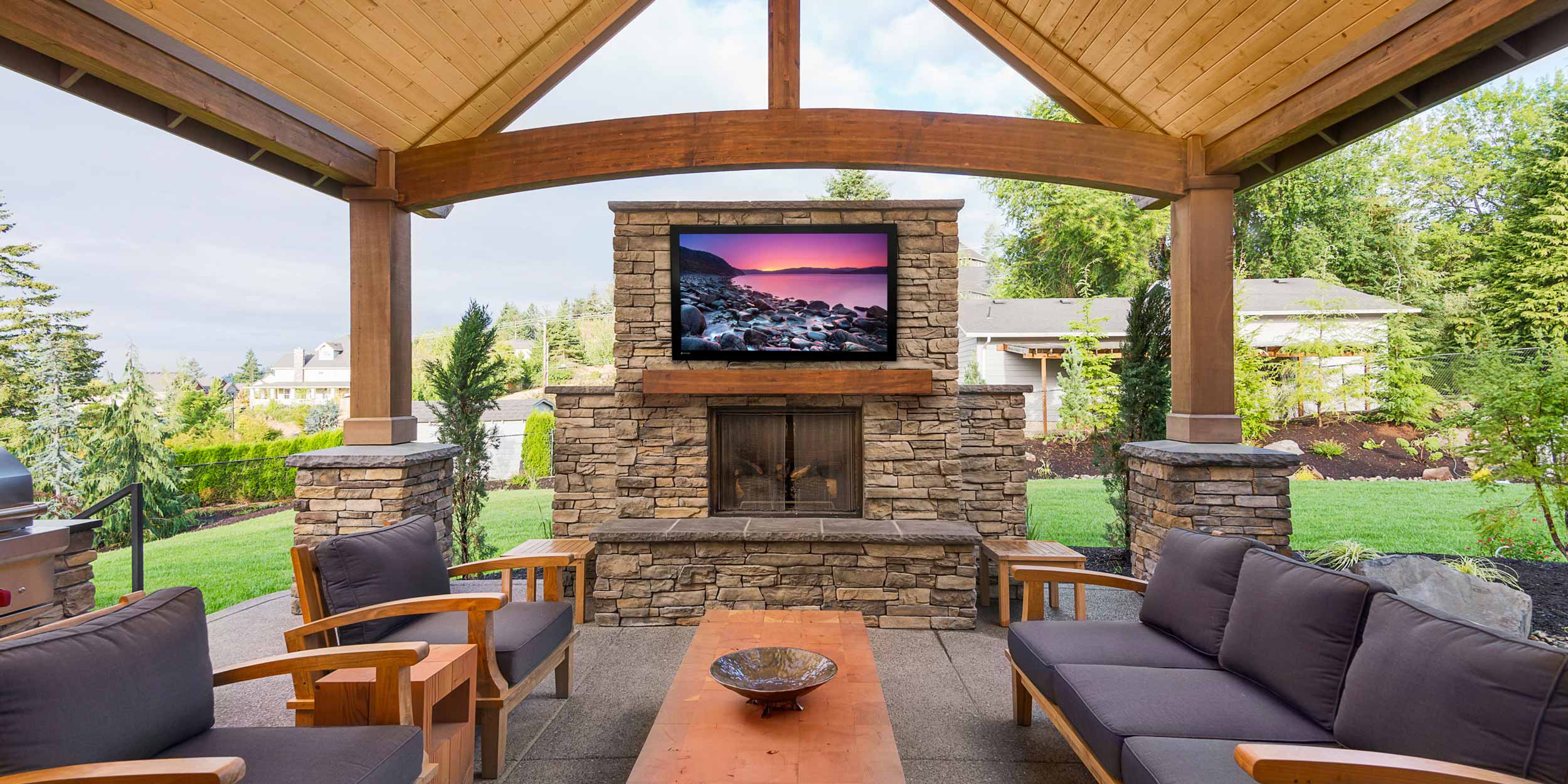 wooden porch furniture in front of white home with palm trees