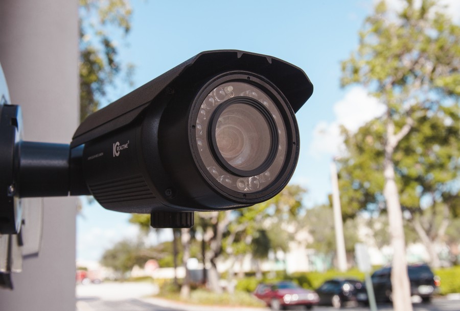 IC Realtime outdoor security camera mounted on a wall, facing a street