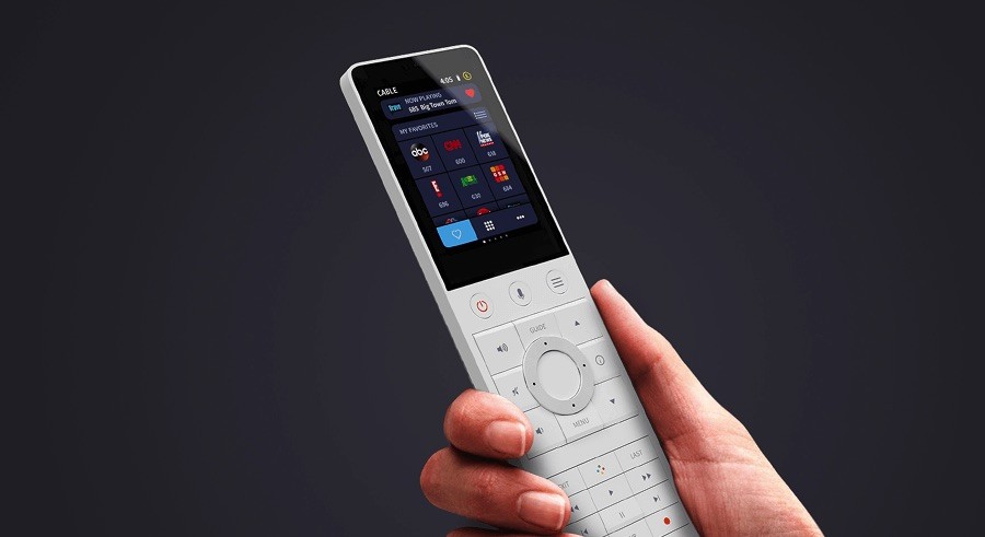 Closeup of a person holding a Crestron remote in their hand.