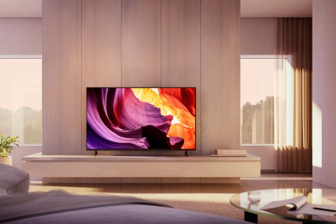 living room with a flat-screen Sony LED 4K UHD TV on a minimalist wood console, displaying vibrant abstract visuals in a bright, sunlit space.
