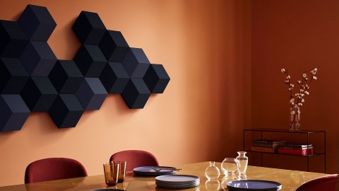B&O Beosound Shape speaker from Bang & Olufsen hung on the wall of a simple dining room.