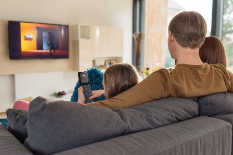 A family watches TV on an entertainment system controlled by home automation in a Bay Area home. 