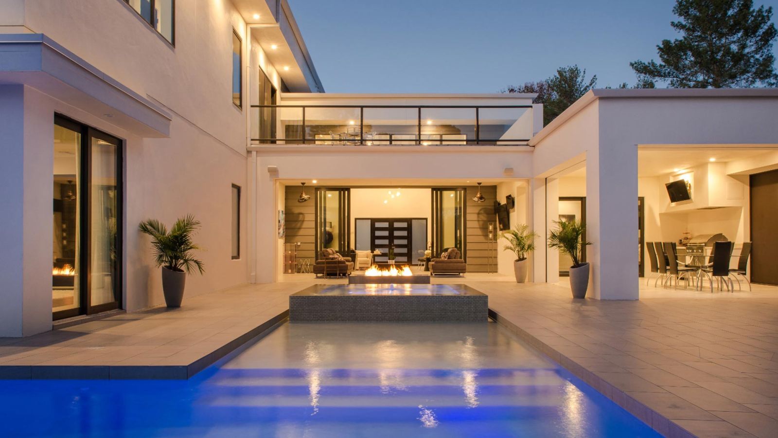 Contemporary home exterior with pool, fire feature, and outdoor seating area