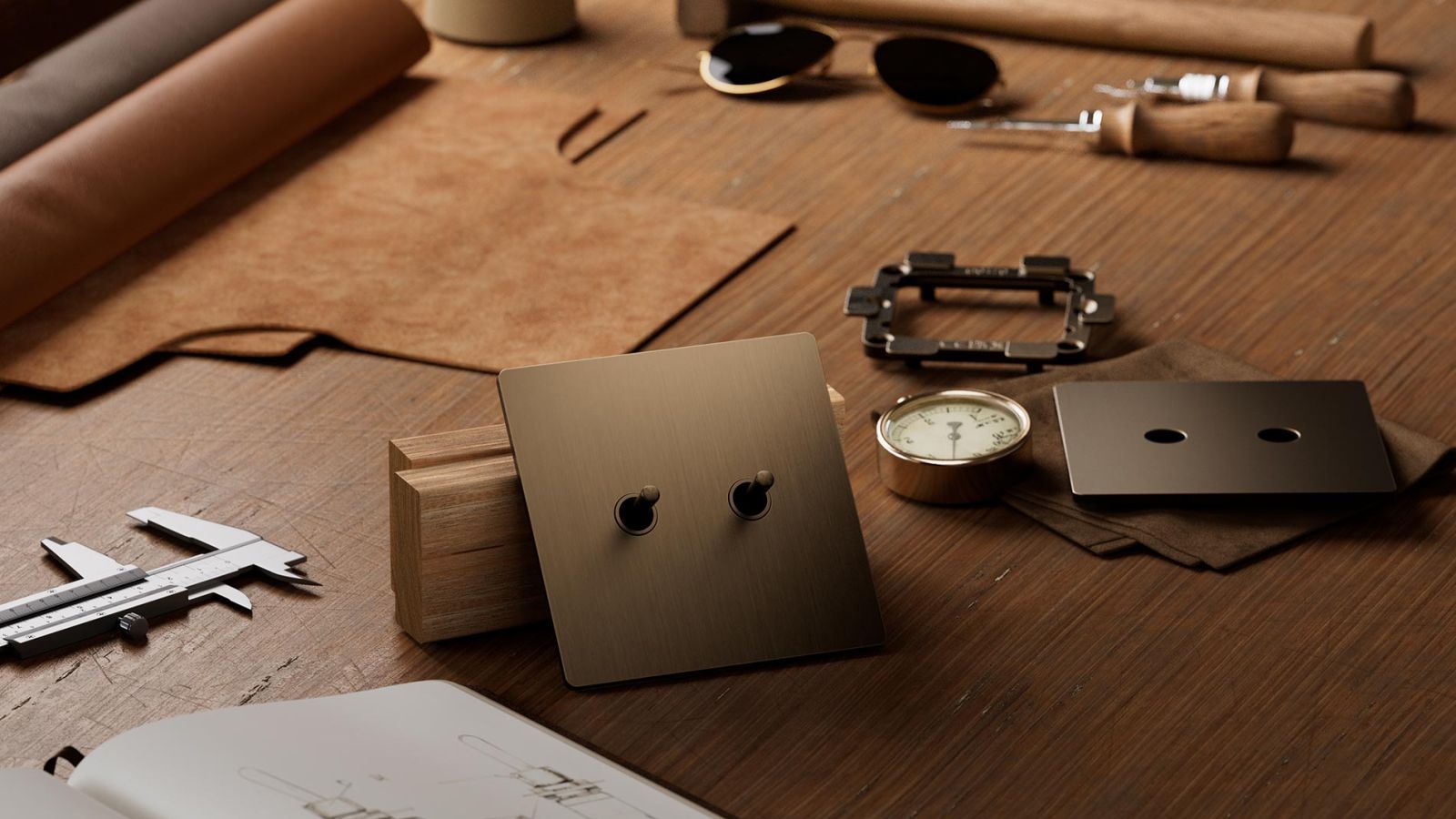 Brass toggle light switch on workbench surrounded by tools and sketches