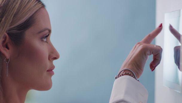 Woman interacting with crestron touch panel